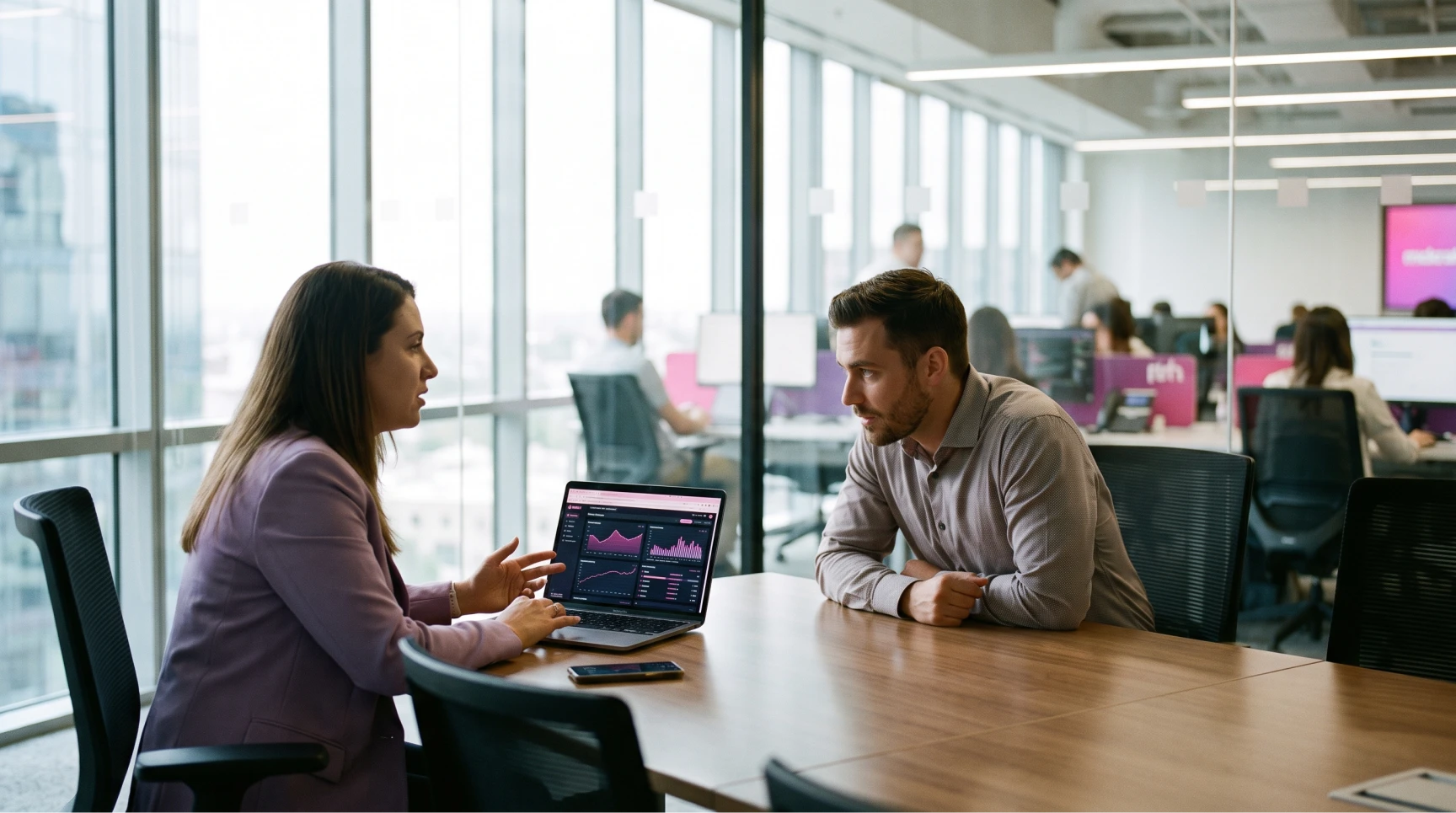 Uma consultora de talent acquisition de uma consultoria de recrutamento especializado apresenta dados de um processo seletivo em um laptop para um parceiro de negócios em uma sala de conferência envidraçada de um escritório moderno de tecnologia. A tela do laptop exibe dashboards de dados complexos para otimizar o recrutamento para startups. No fundo, através do vidro, outros profissionais tech e membros de um time comercial SaaS trabalham, ilustrando a cultura organizacional e os esforços de employer branding. A cena destaca o uso de dados para reduzir o time to hire e apoiar o recrutamento escalável para crescimento acelerado.